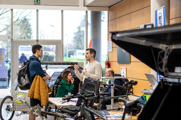 En premier plan 2 hommes discutent autour d'un stand