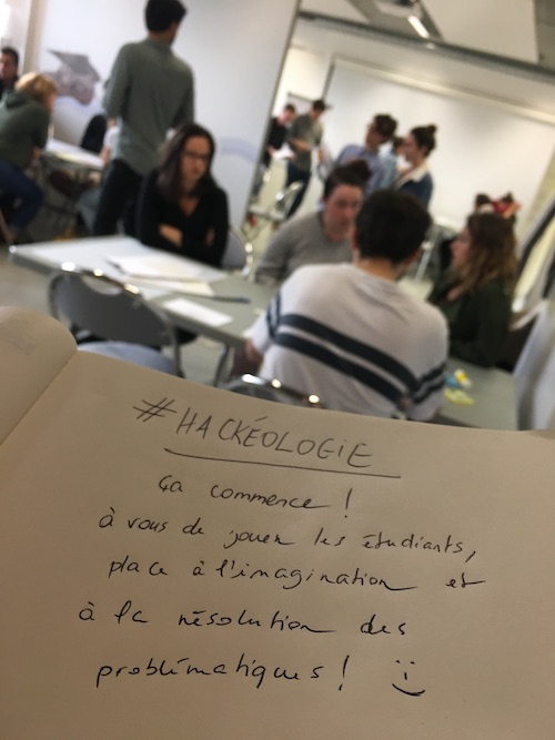 Photo d'un carnet sur lequel il est écrit : Hackéologie, ça commence ! à vous de jouer les étudiantes places à l'imagniation et à la résolution des problématiques